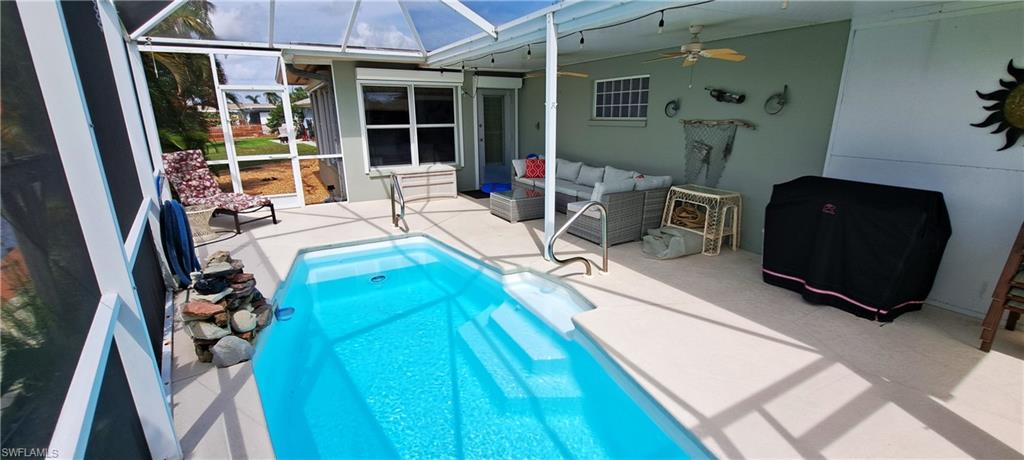 View of swimming pool featuring outdoor lounge area, ceiling fan, a lanai, and a patio area