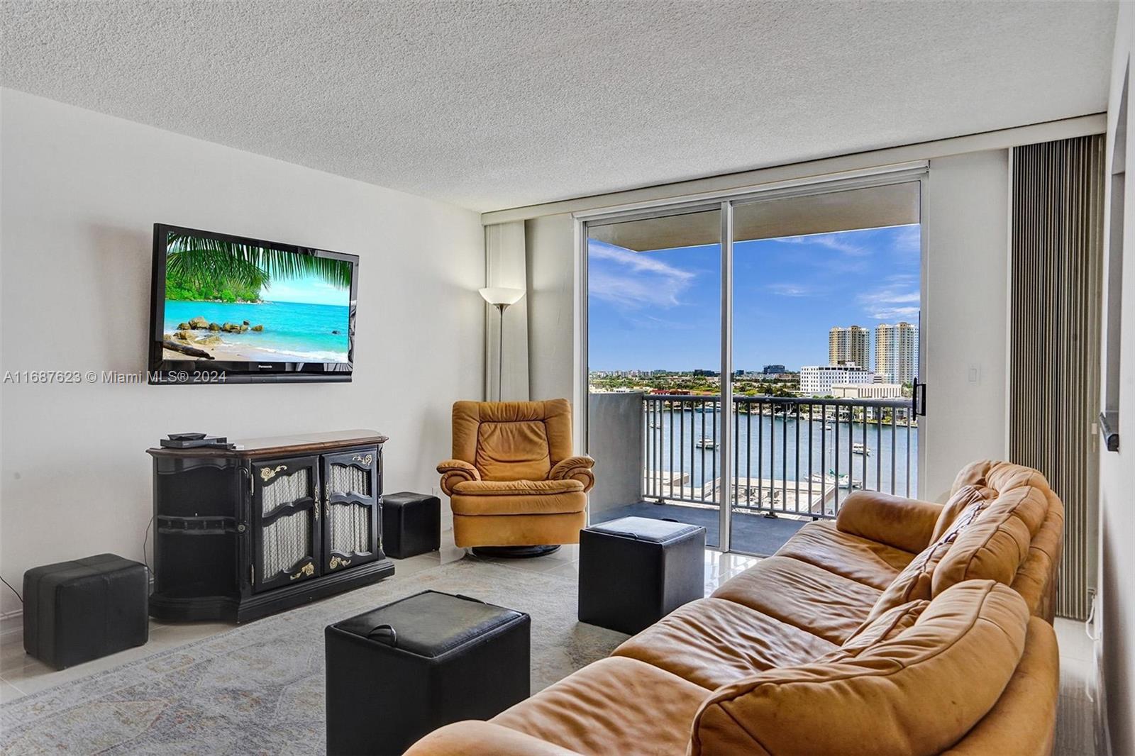 a living room with furniture a floor to ceiling window and a flat screen tv