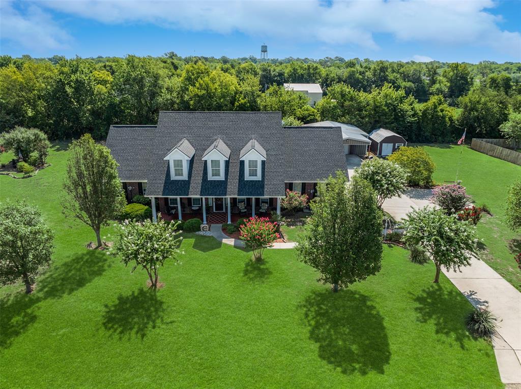 an aerial view of a house with a yard and a large pool