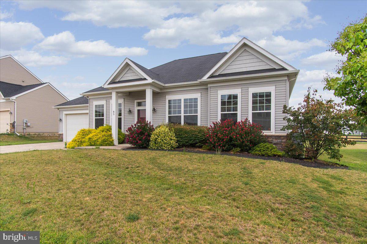 a view of a house next to a yard with plants and trees