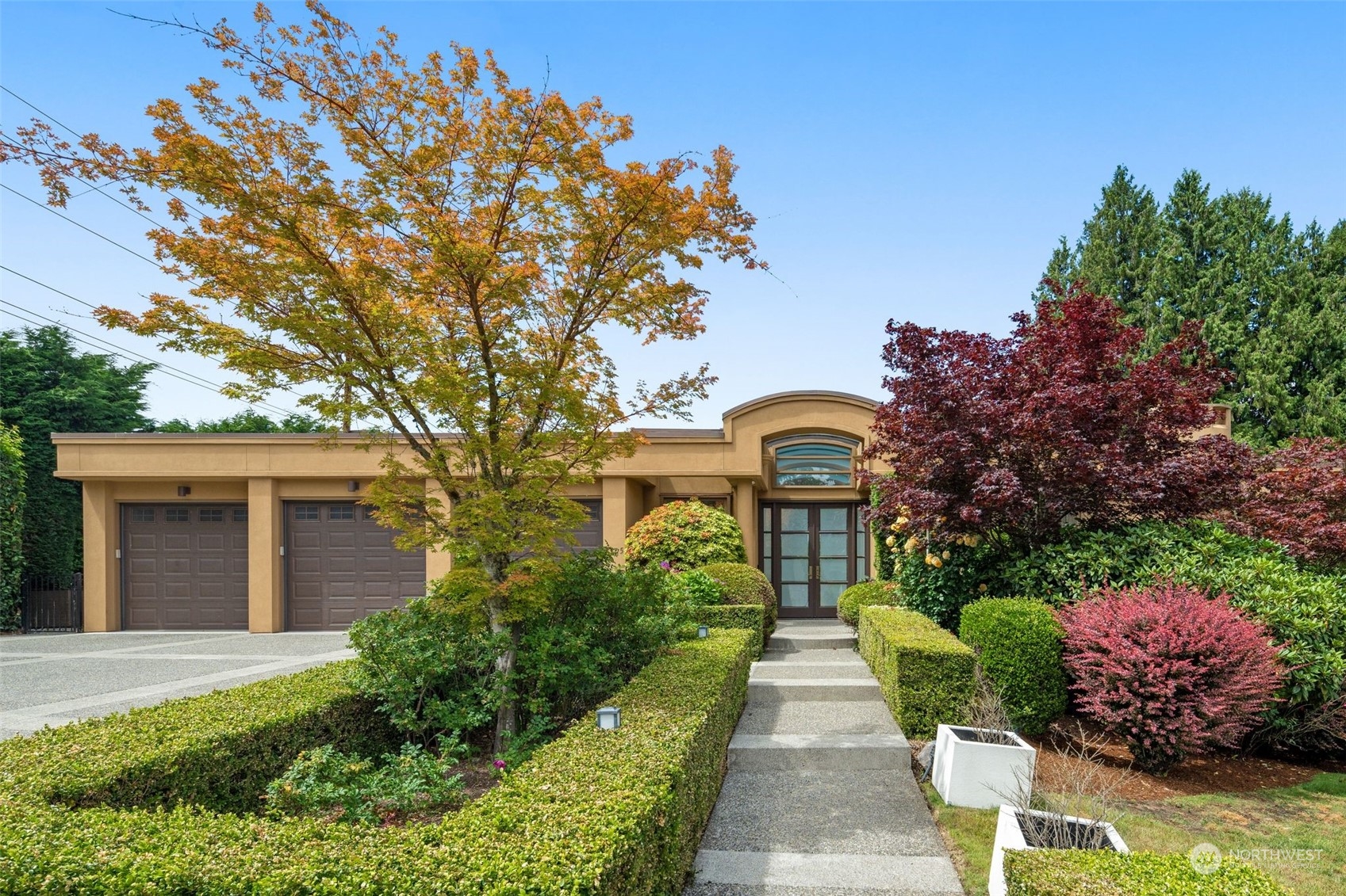 a front view of a house with a yard and potted plants