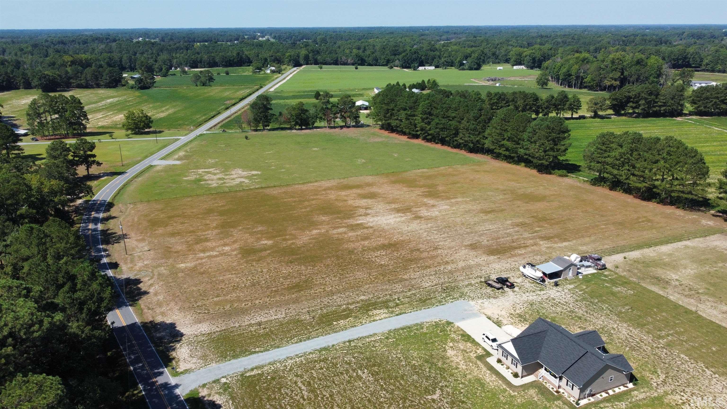 an aerial view of a house with a yard and lake view