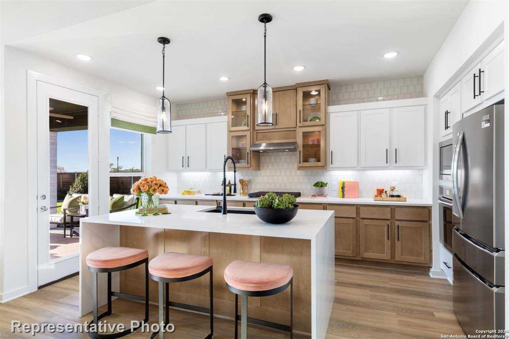 a kitchen with stainless steel appliances a table chairs refrigerator and sink