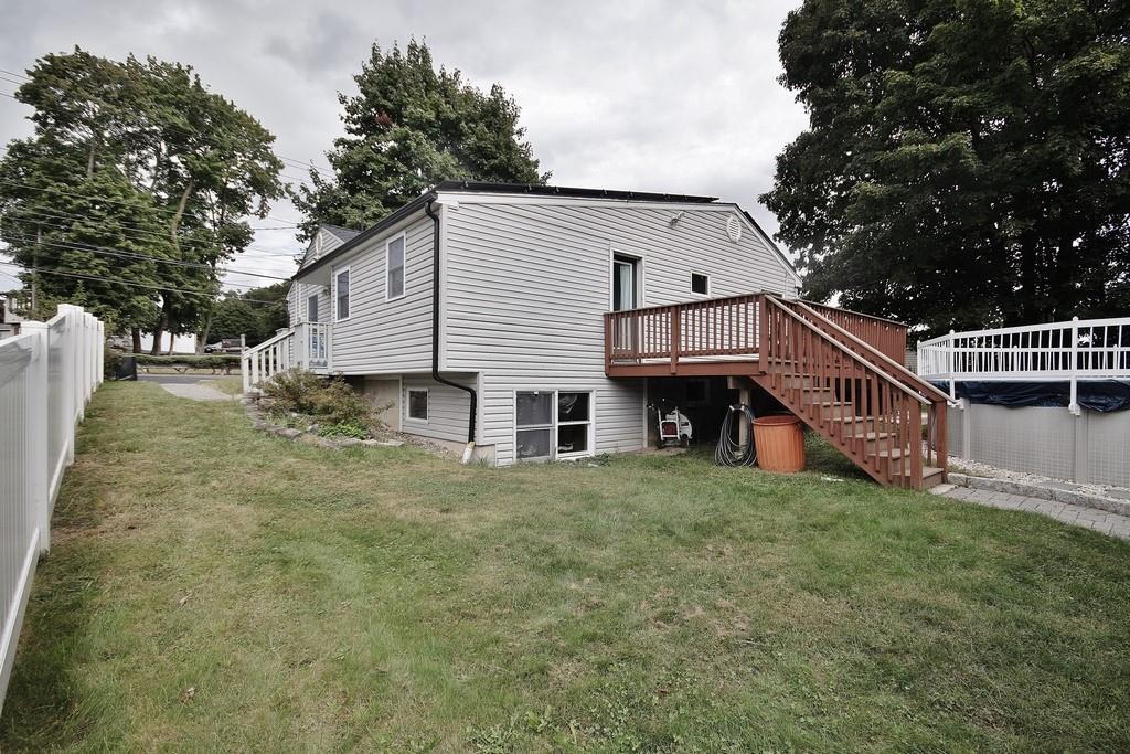 Rear view of house with a yard and a wooden deck