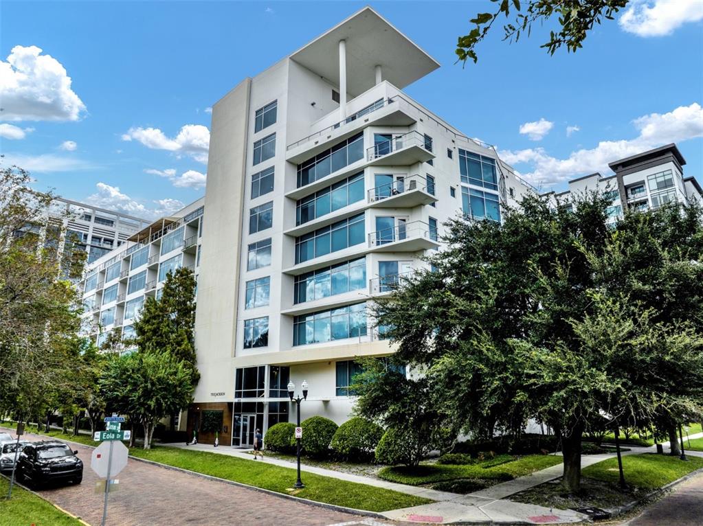 a front view of a building with street view and trees