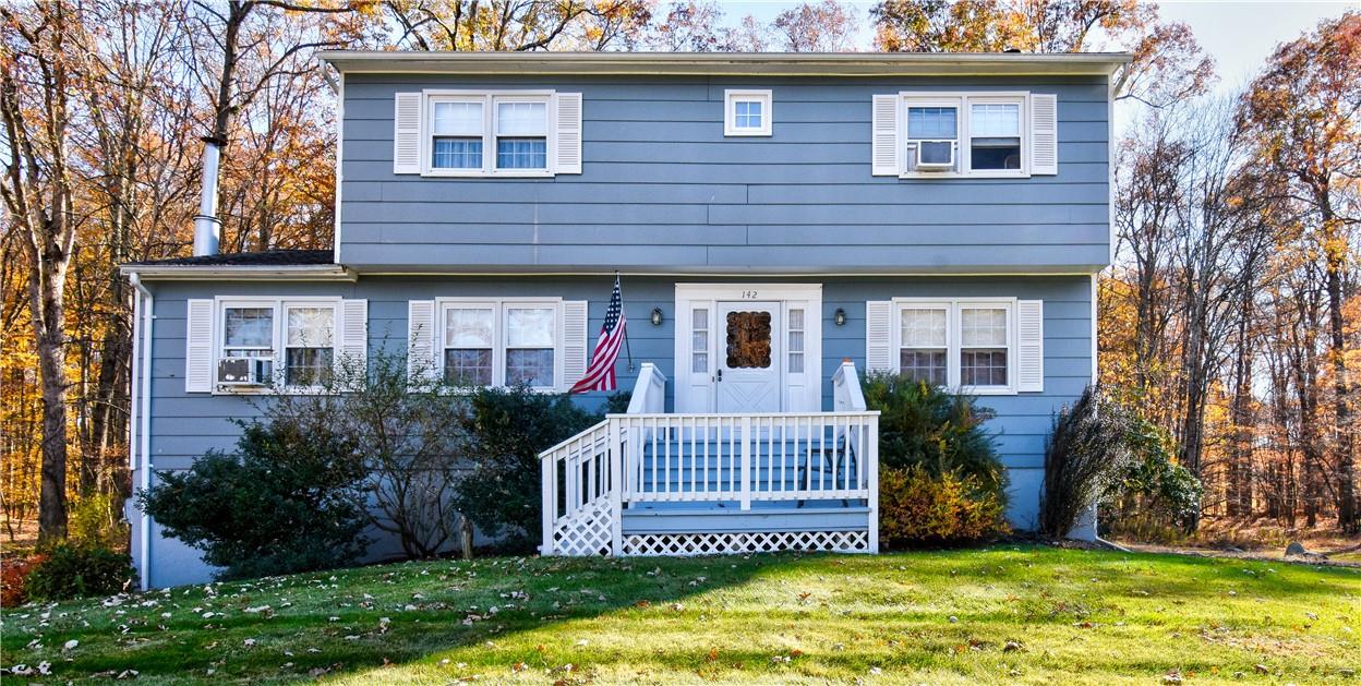 View of front facade featuring a front lawn and a deck