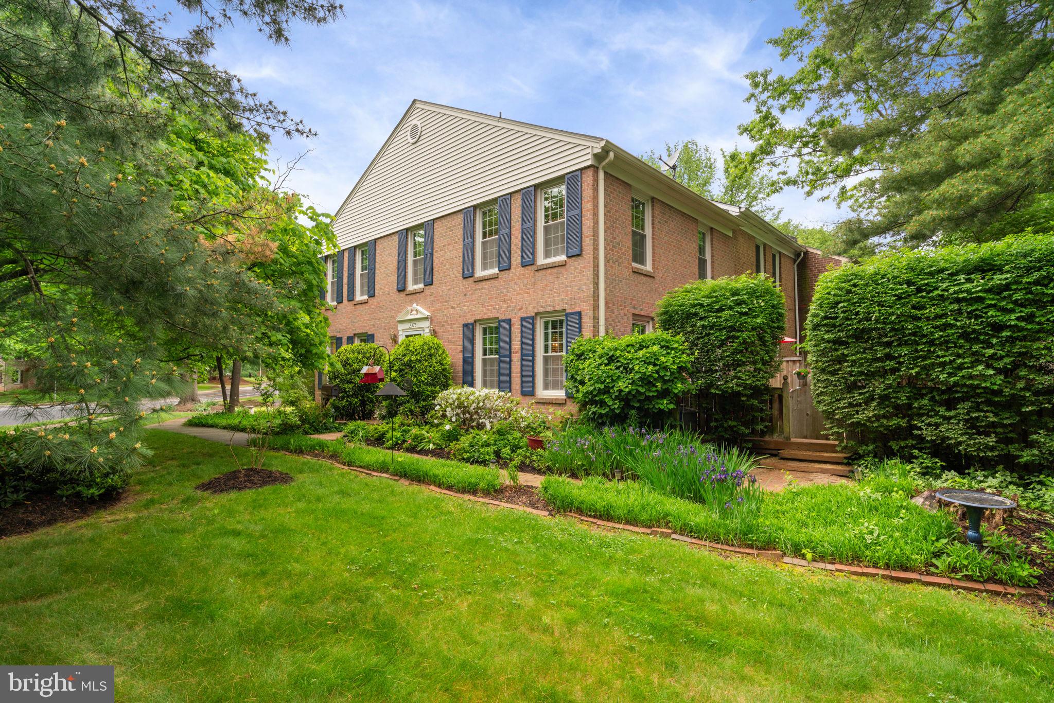 a front view of a house with a yard and trees