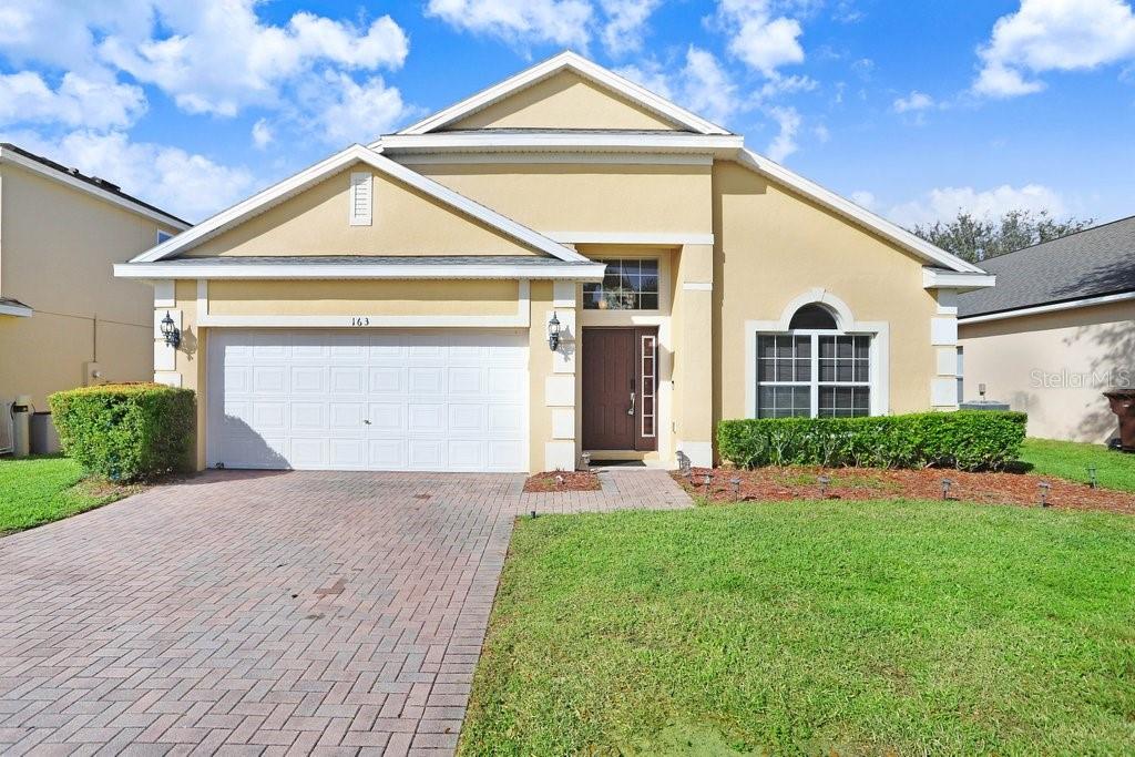 a front view of a house with a yard and garage