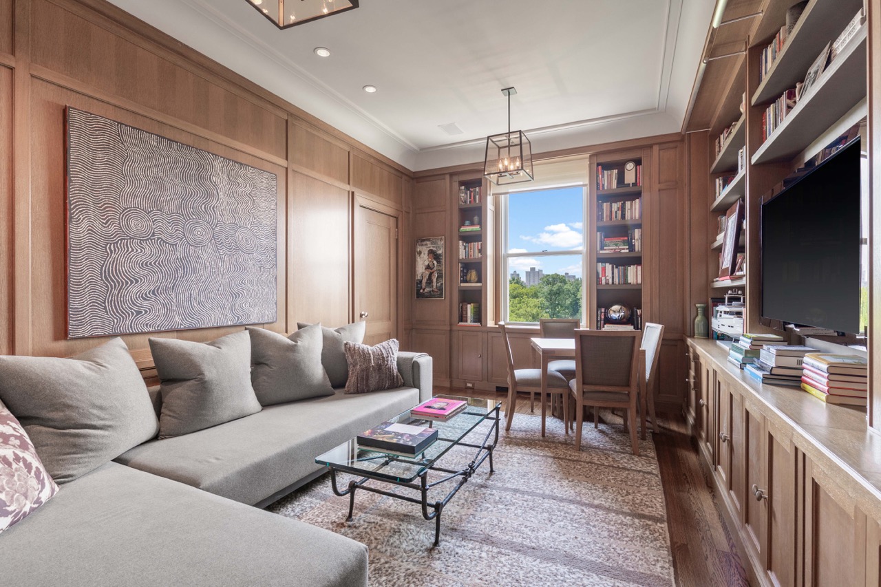 a living room with furniture a flat screen tv and a large window