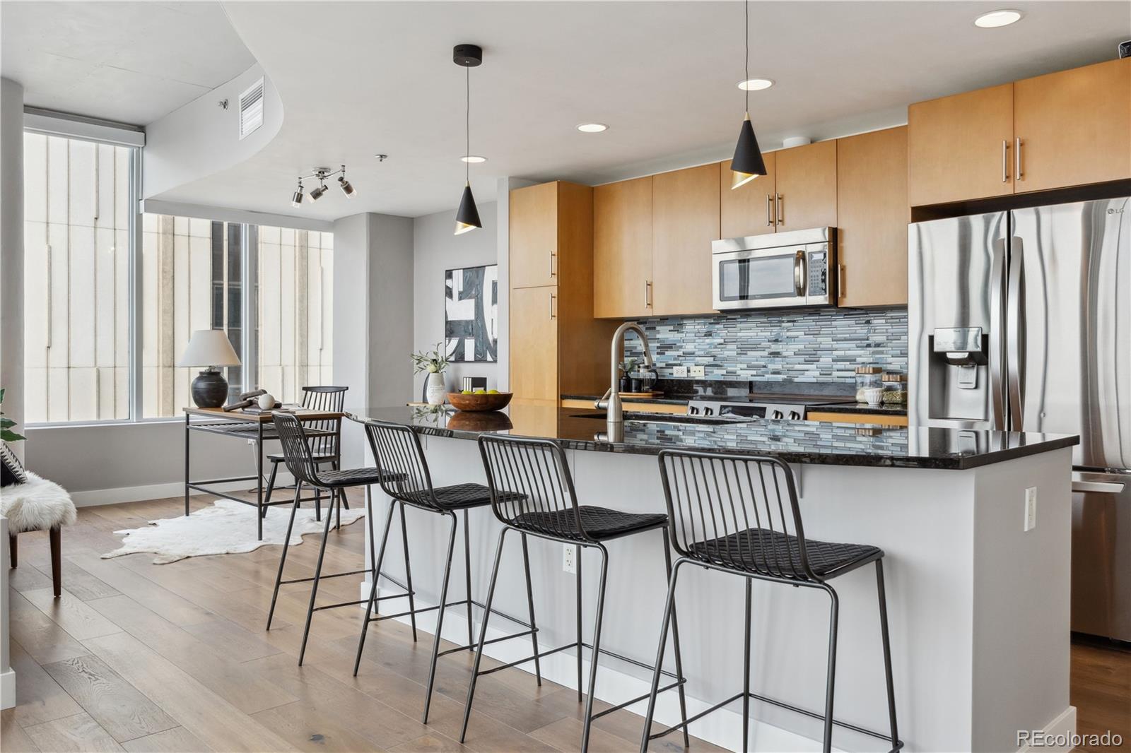 a kitchen with stainless steel appliances kitchen island granite countertop a stove a sink and a refrigerator