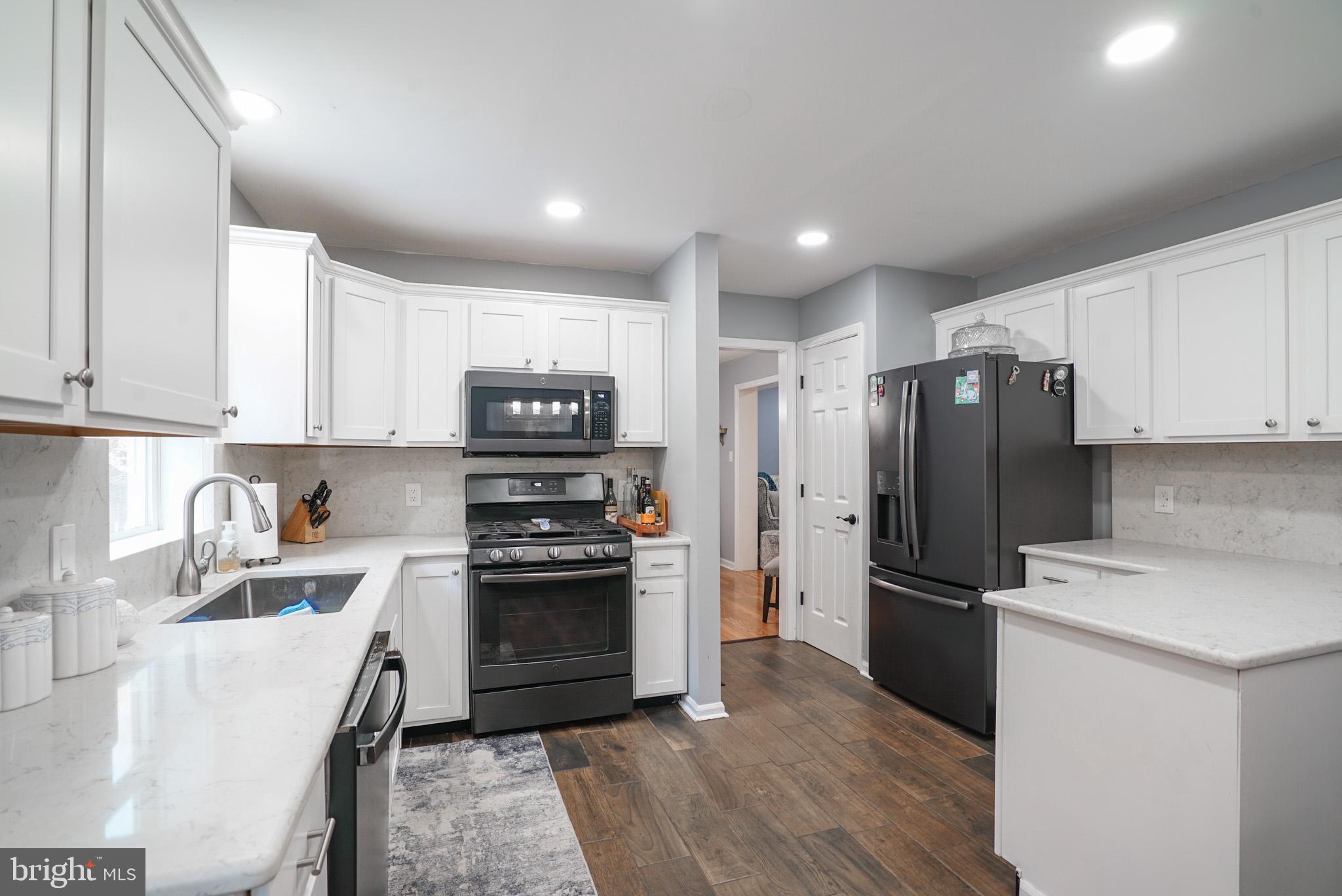 a kitchen with stainless steel appliances granite countertop a refrigerator sink and stove