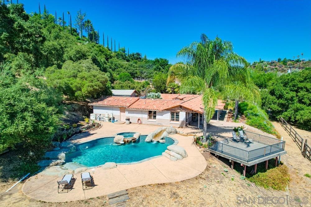 an aerial view of a house with garden space and trees all around