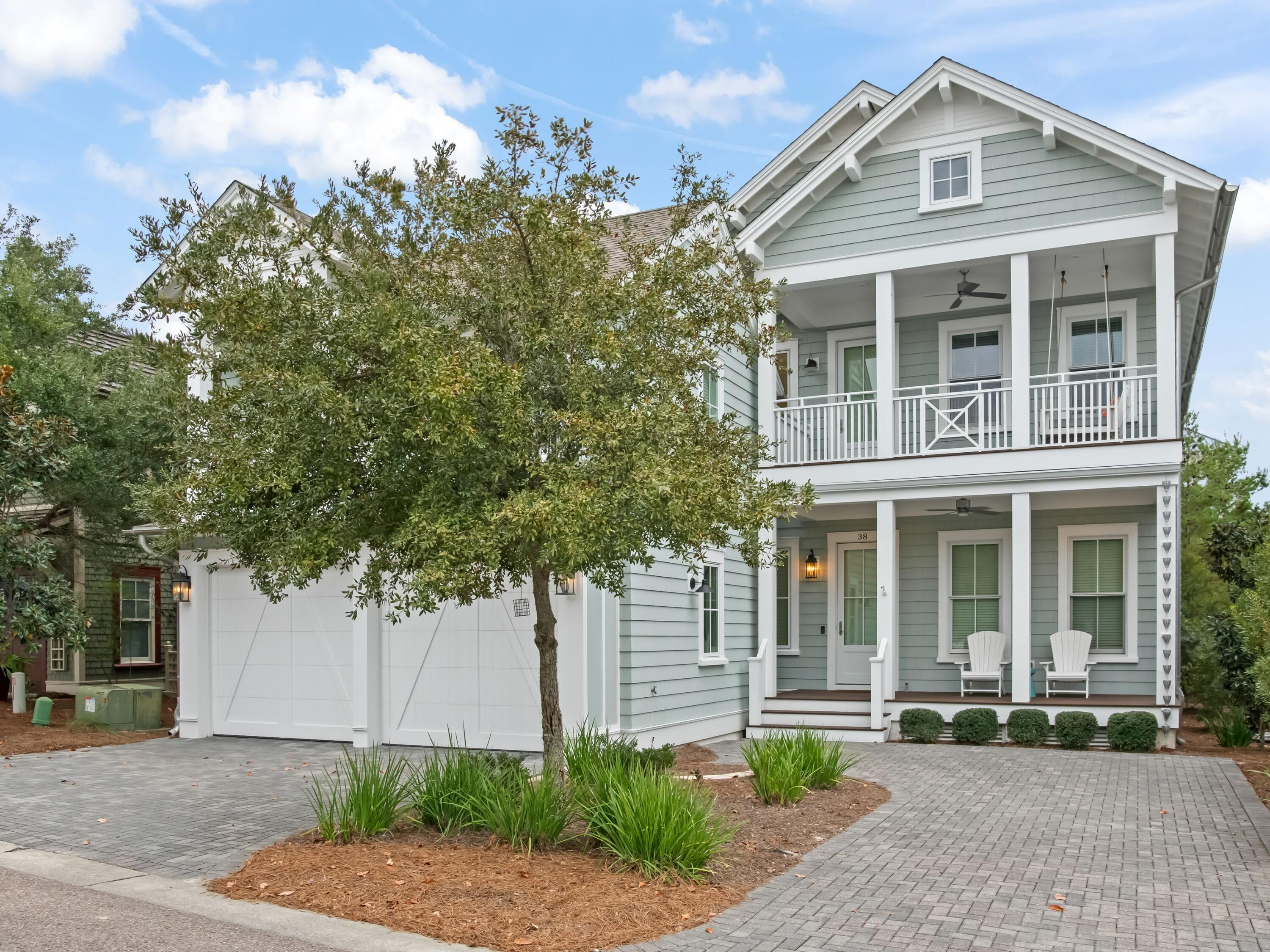 a front view of a house with a yard and potted plants