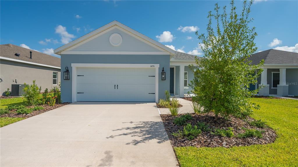 a front view of a house with a yard and garage