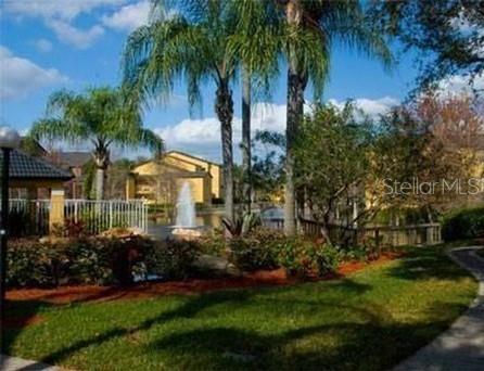 a view of a house with a yard and potted plants