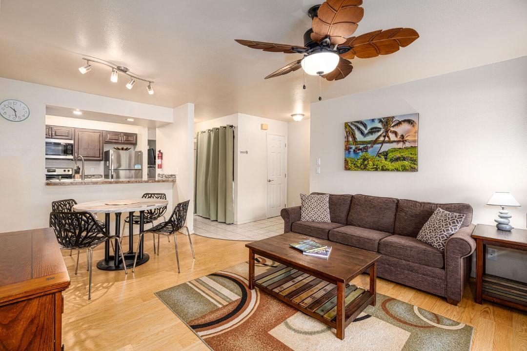 a living room with furniture a refrigerator and kitchen view