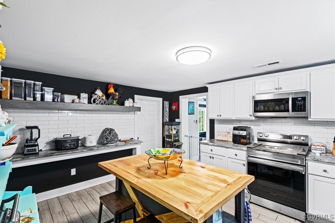 a kitchen with a sink a stove and cabinets