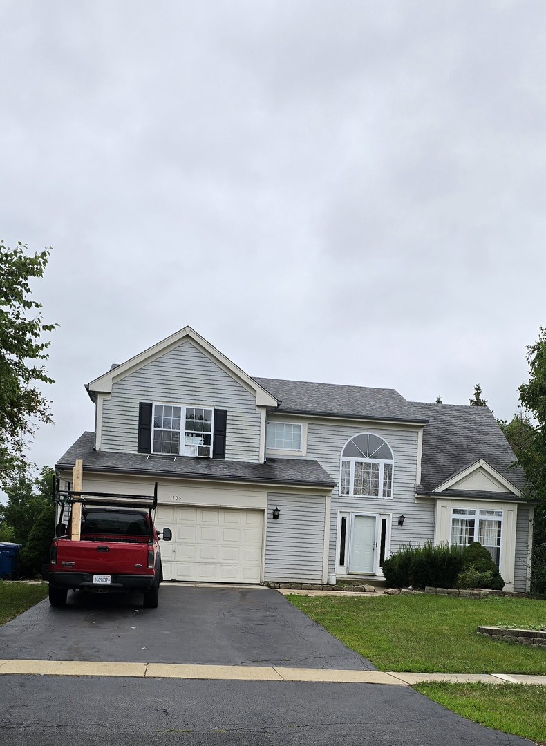 a front view of a house with a garden and parking