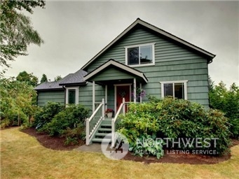 a front view of a house with yard and green space