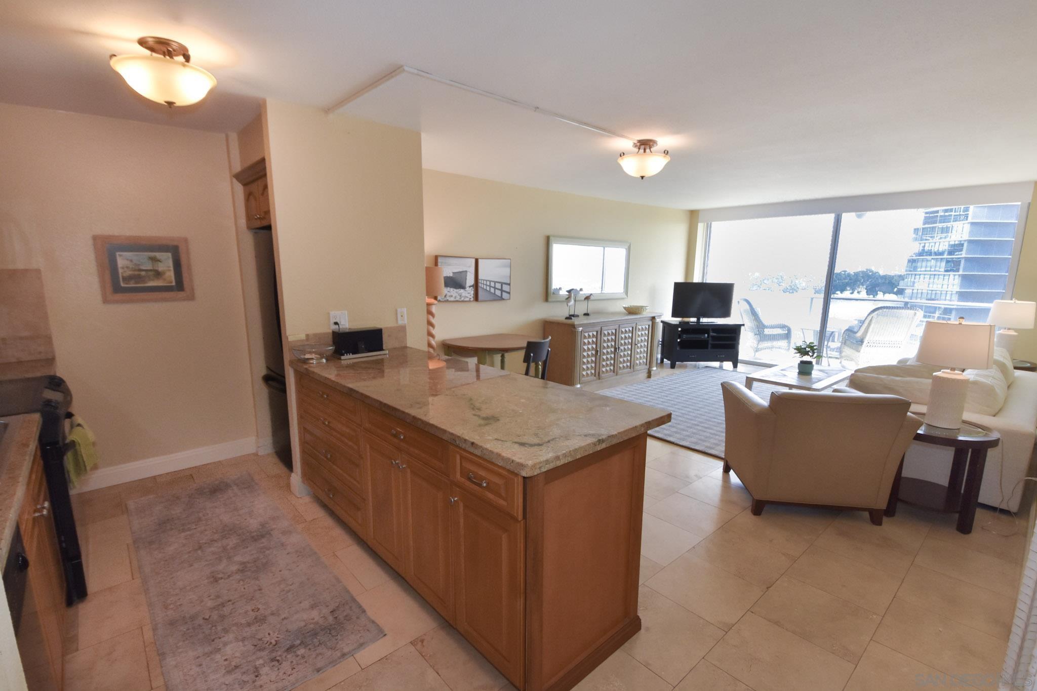 a living room with stainless steel appliances granite countertop furniture and a kitchen view