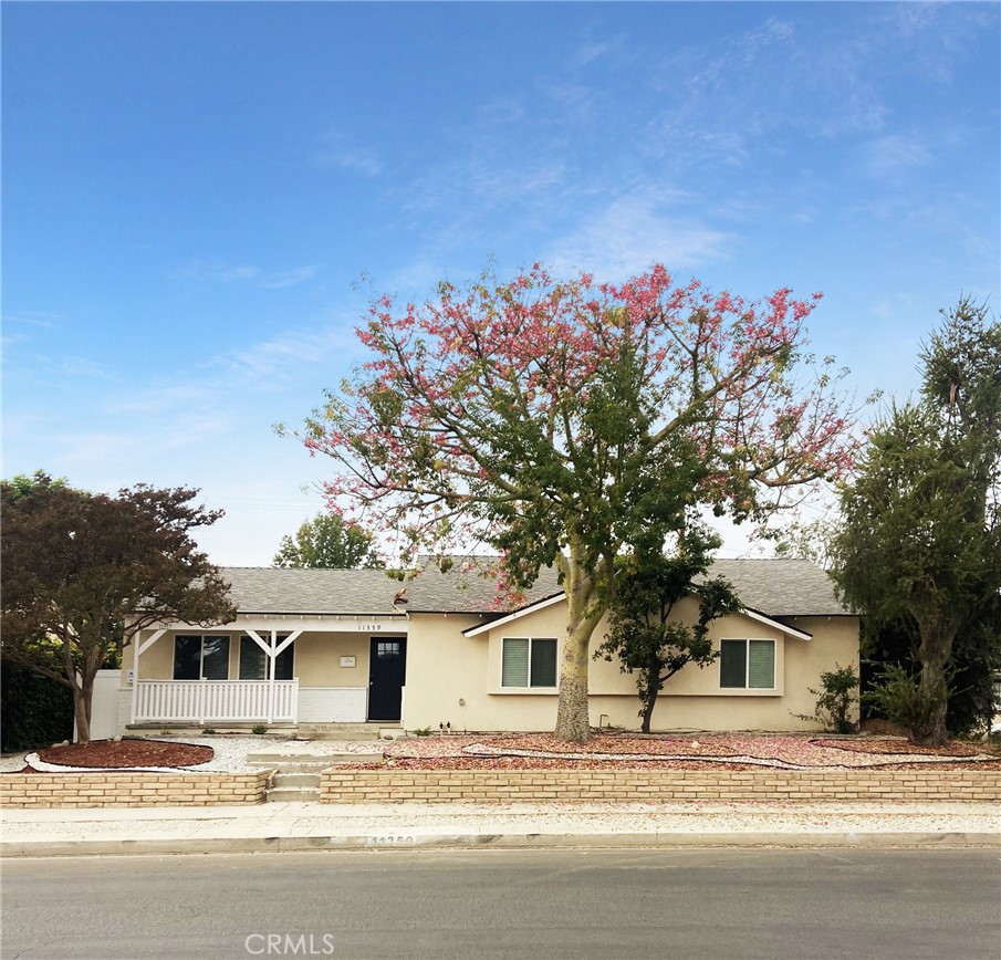 a front view of a house with a tree