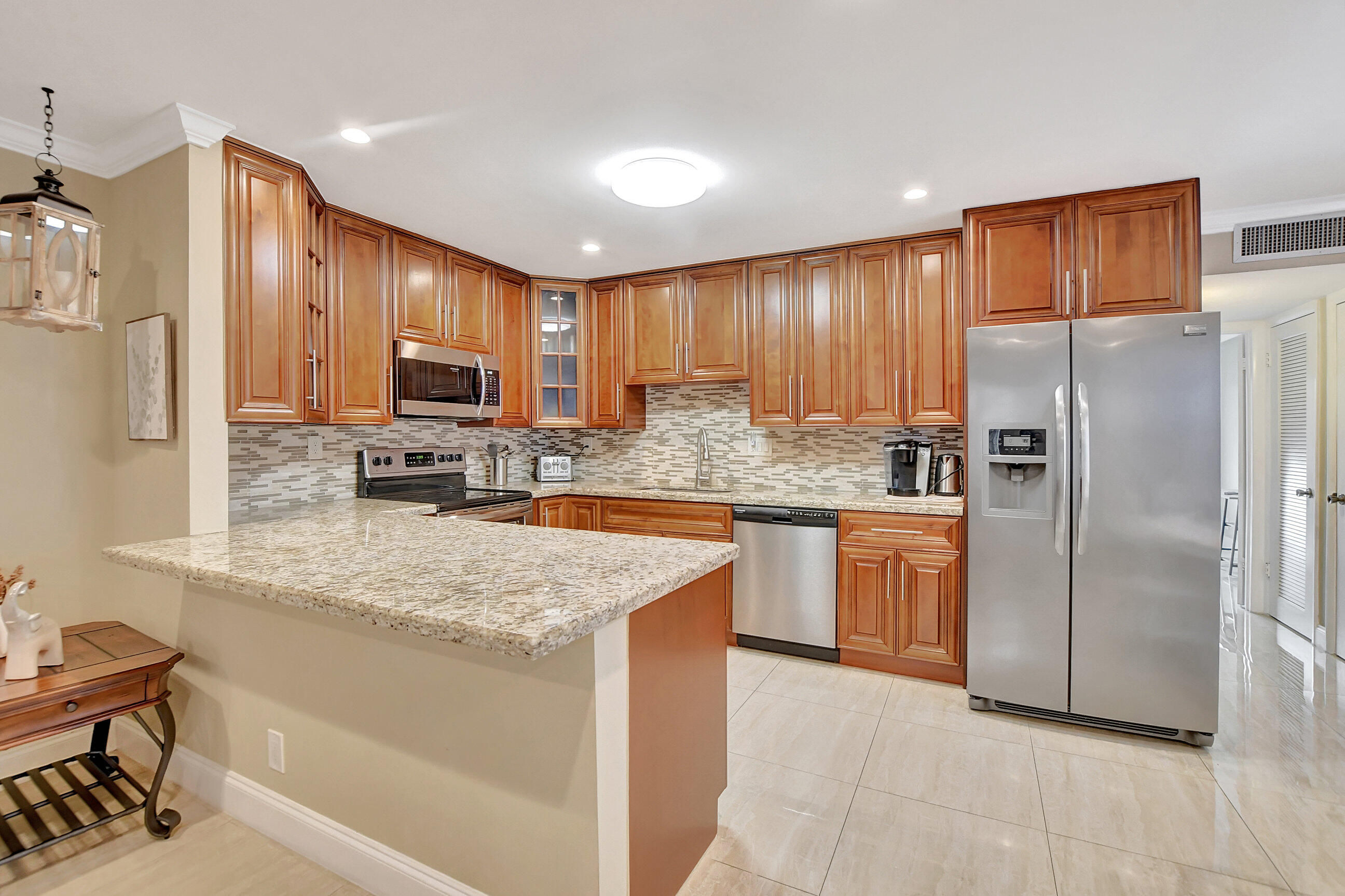 a kitchen with stainless steel appliances granite countertop a refrigerator and a stove top oven