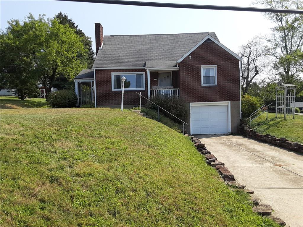 a front view of a house with yard and trees