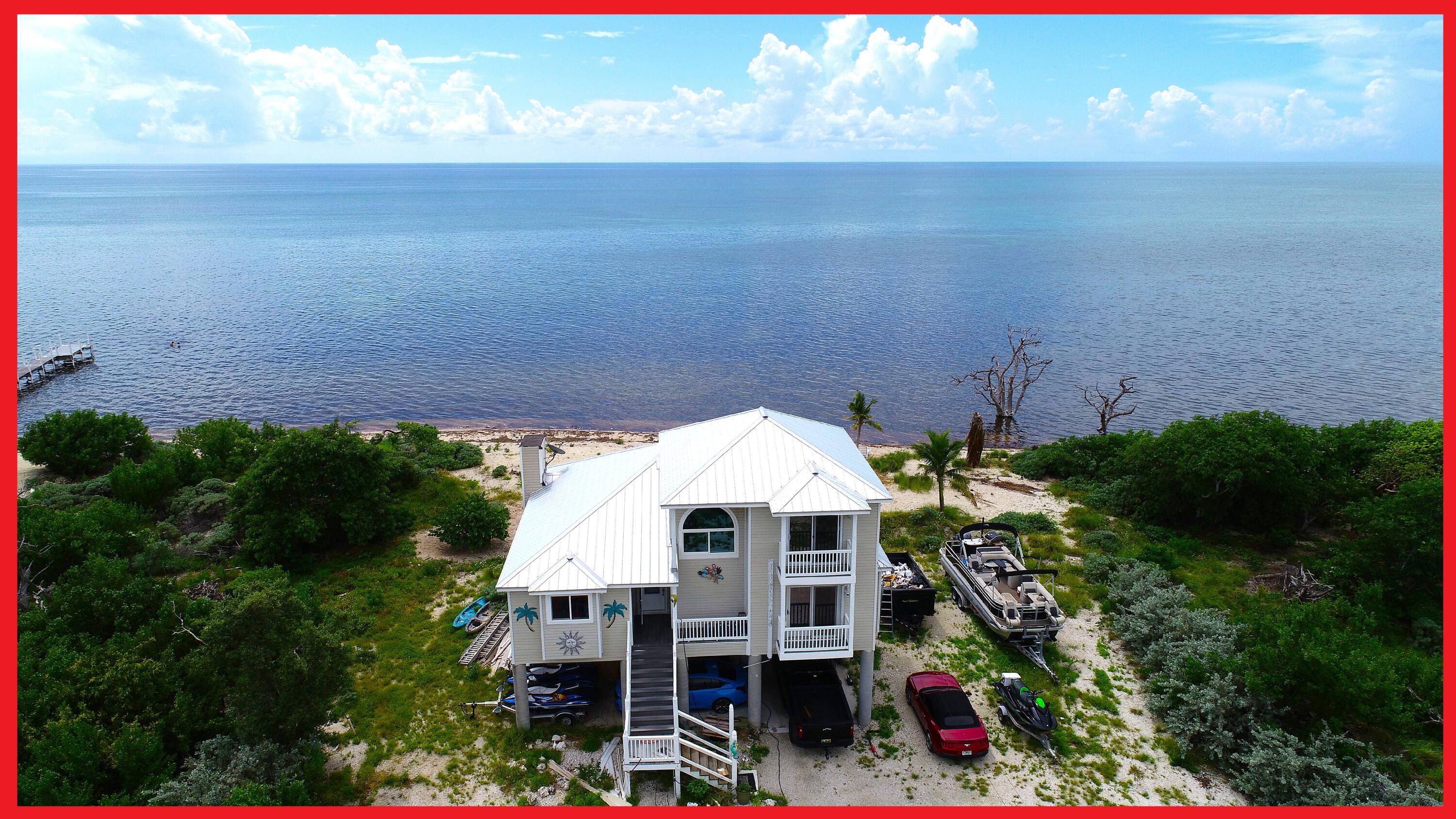 a aerial view of a house with balcony and trees in the background