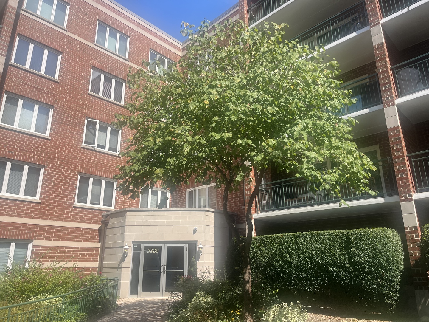 a front view of a building with a tree