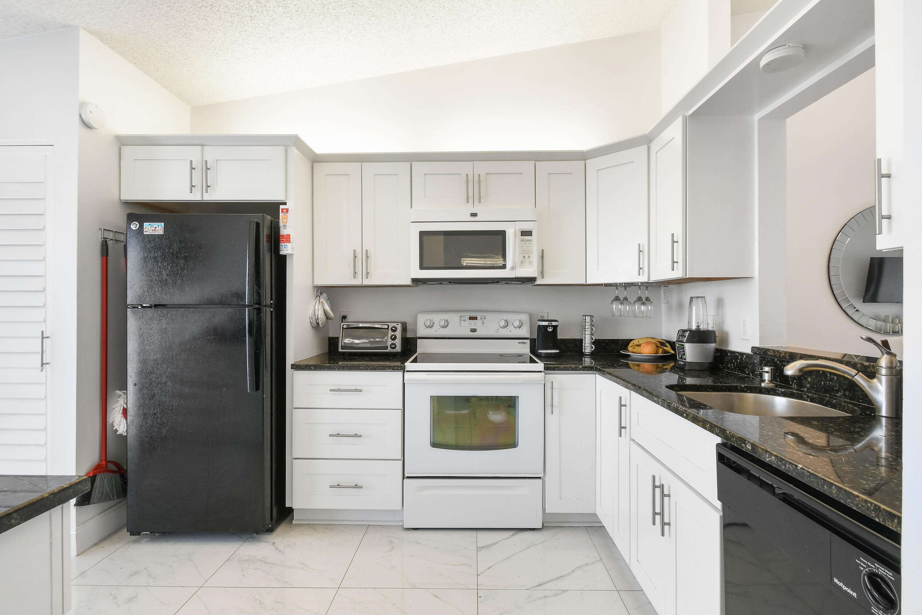 a kitchen with a refrigerator sink and cabinets