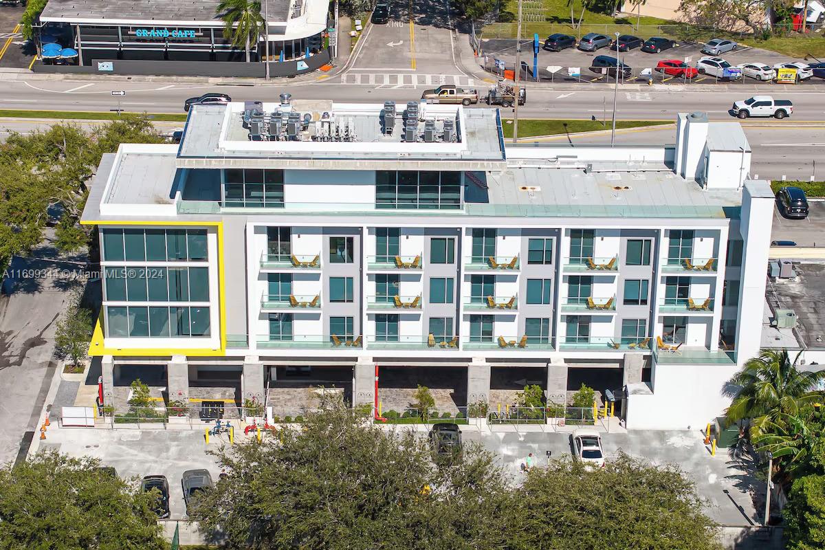 a view of a large building with a lot of windows and plants