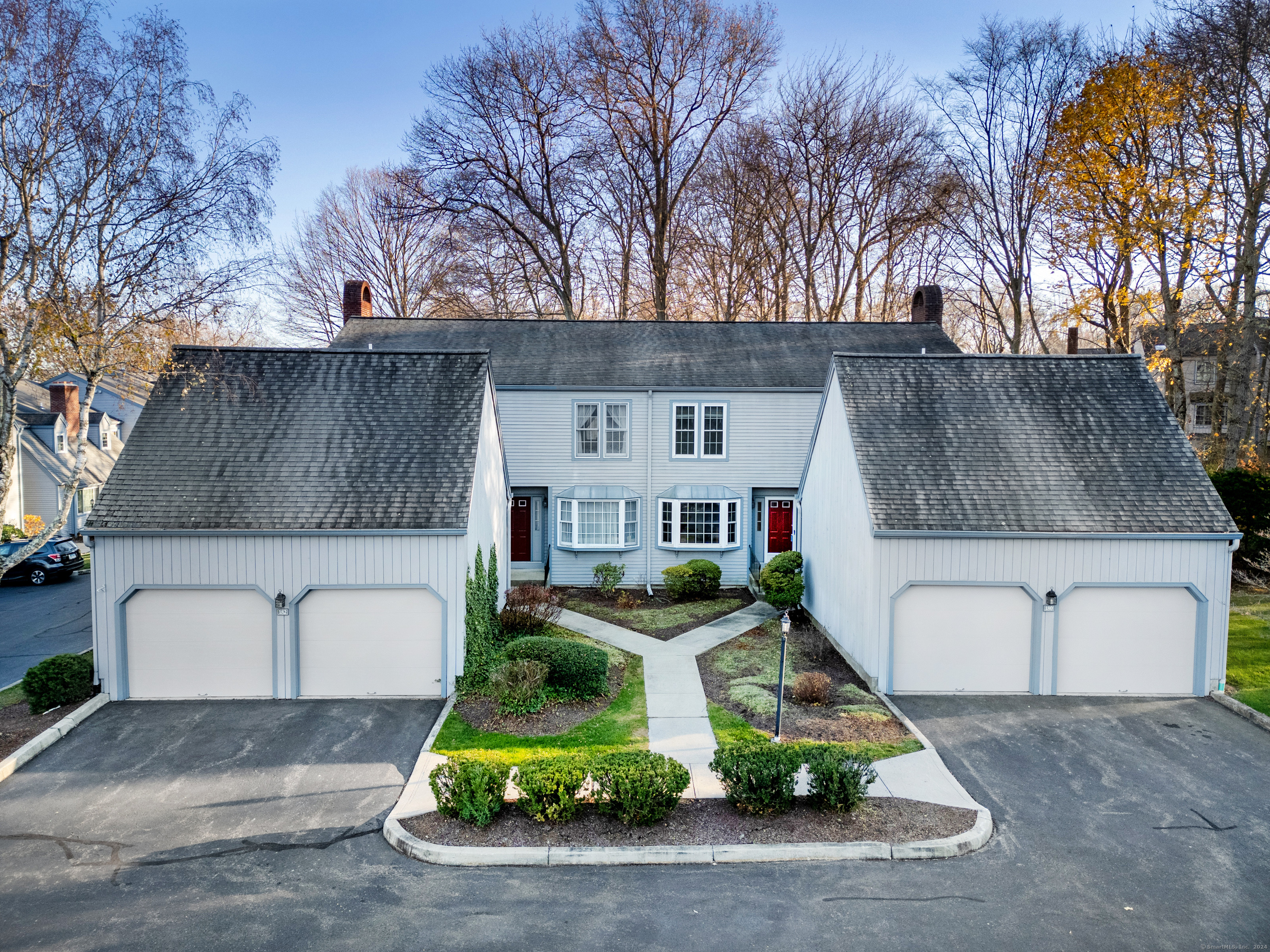 a front view of house with garage and trees