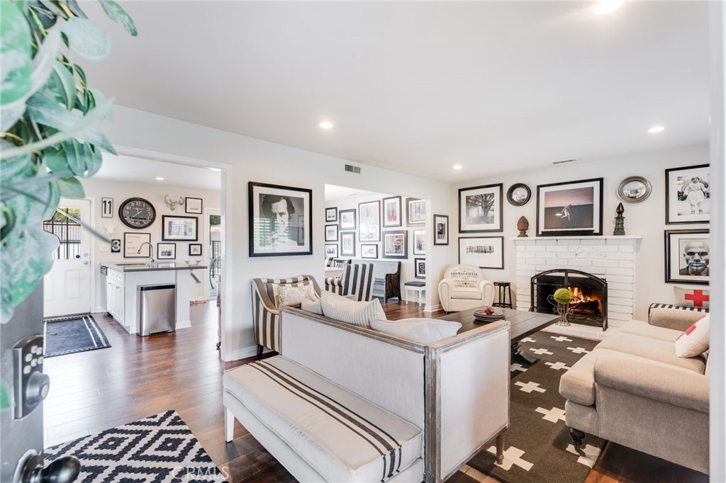 a living room with furniture a fireplace and wooden floor