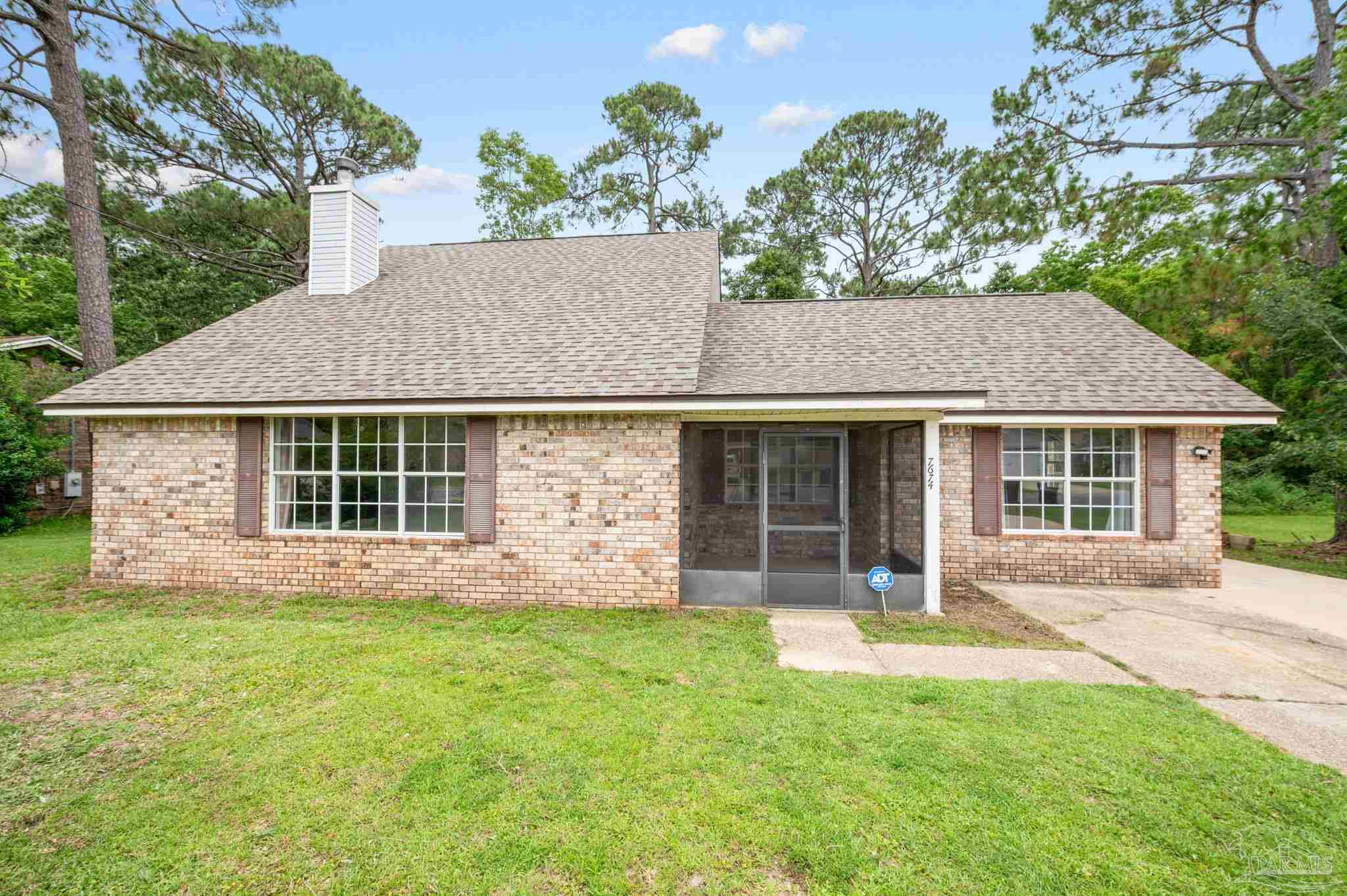 a front view of a house with a garden and yard