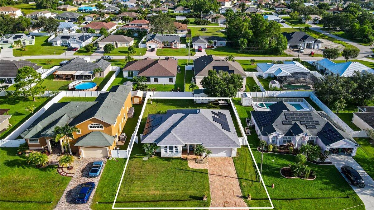 an aerial view of residential houses with outdoor space and parking