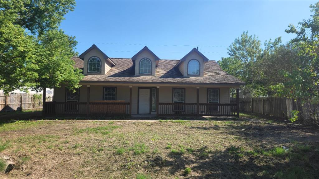 a front view of house with yard and trees around