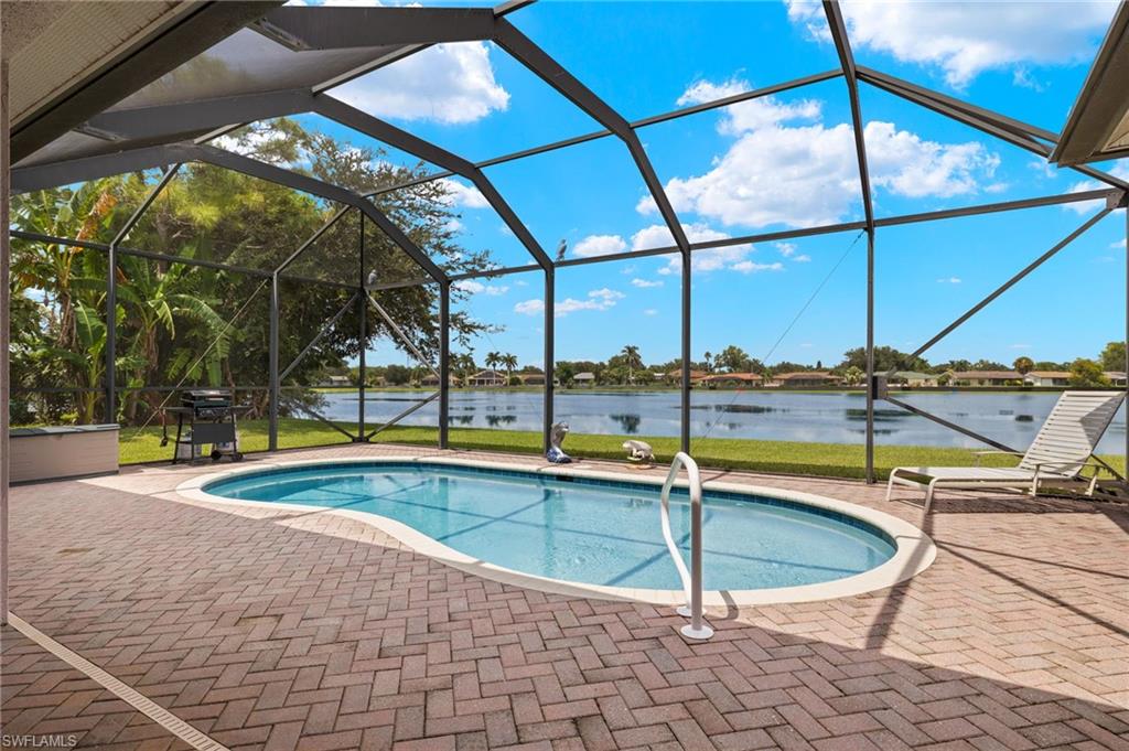 a view of a swimming pool with a chair and tables in the patio