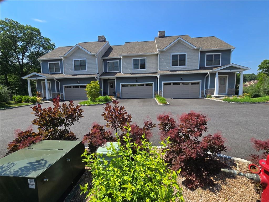 a front view of a house with a yard and a garden