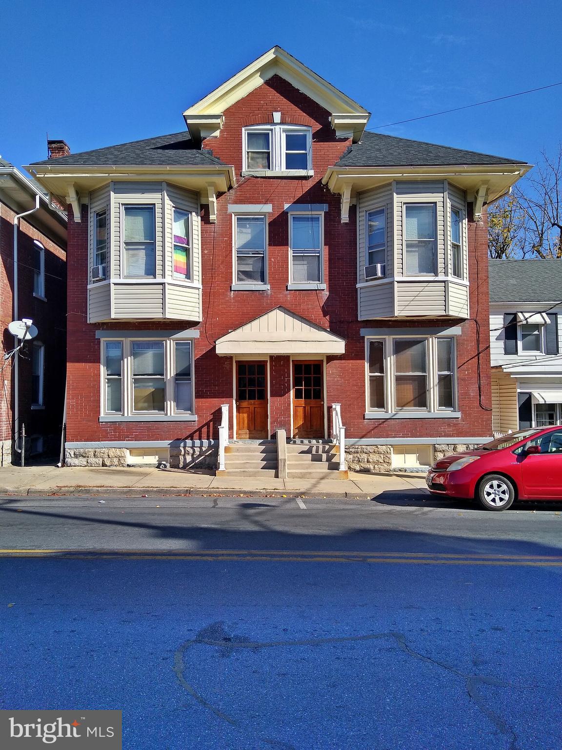 a front view of a residential apartment building with a yard