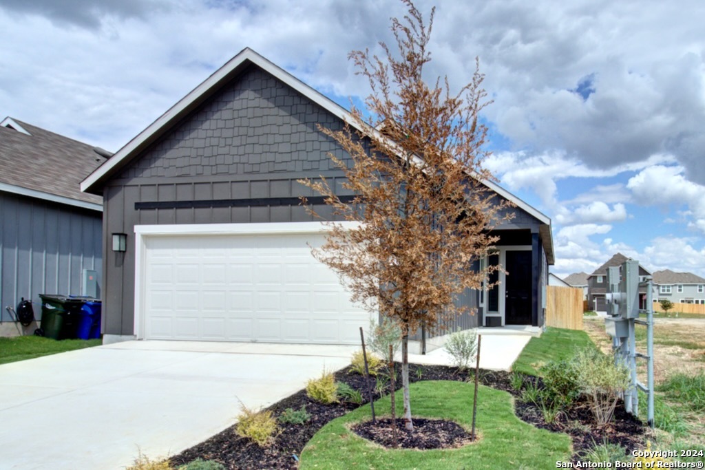 a front view of a house with a garden and plants