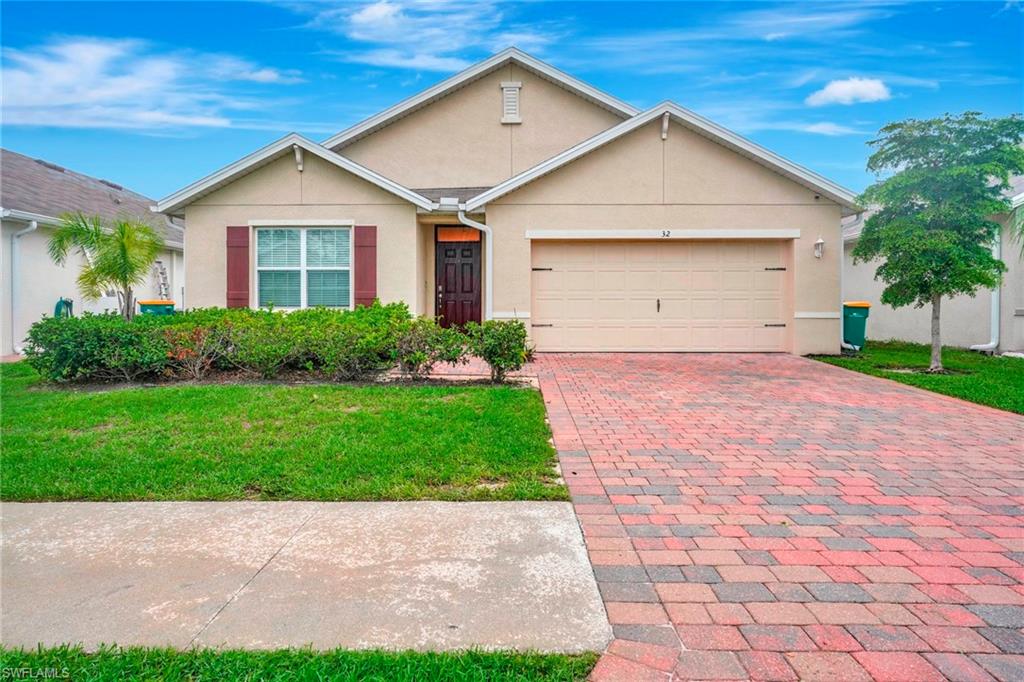 Single story home with a garage and a front yard