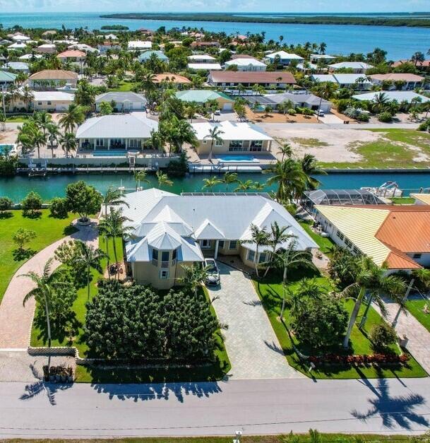 an aerial view of residential houses with outdoor space and lake view