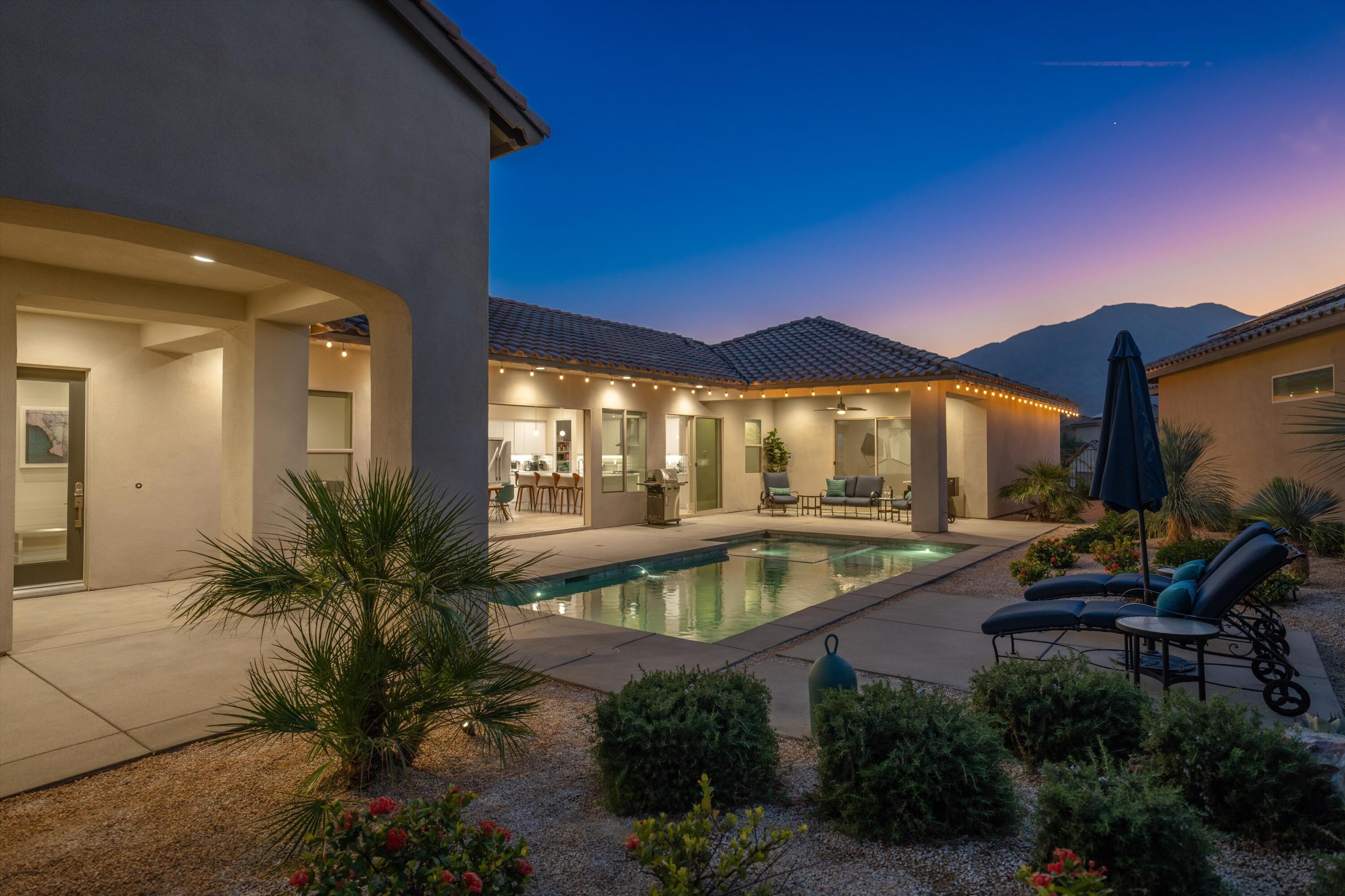 a view of a house with pool and sitting area