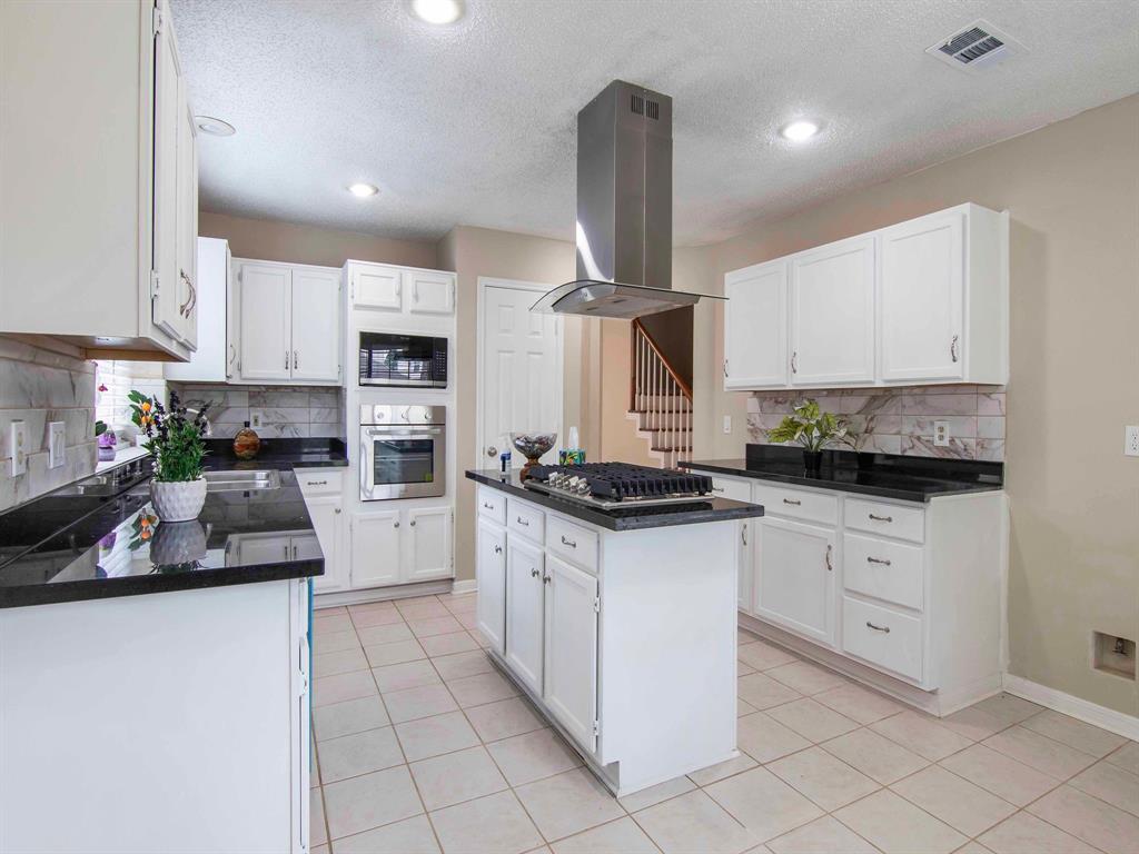 a kitchen with granite countertop white cabinets and white appliances