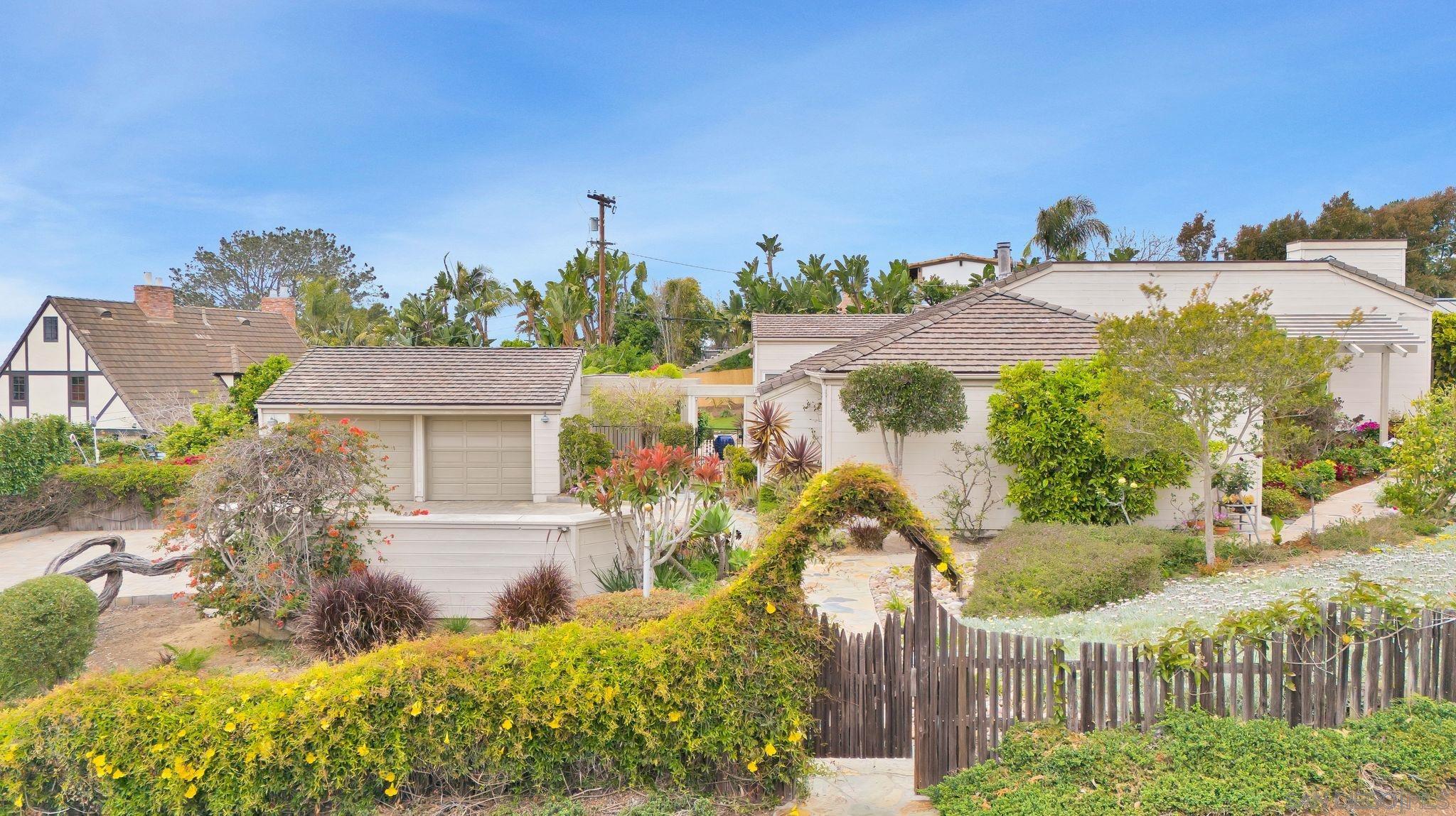 a view of a house with a yard and potted plants