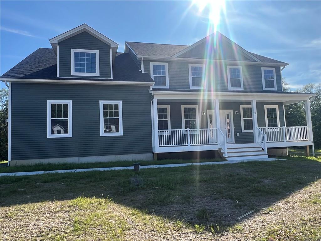 View of front of property with a front yard and covered porch