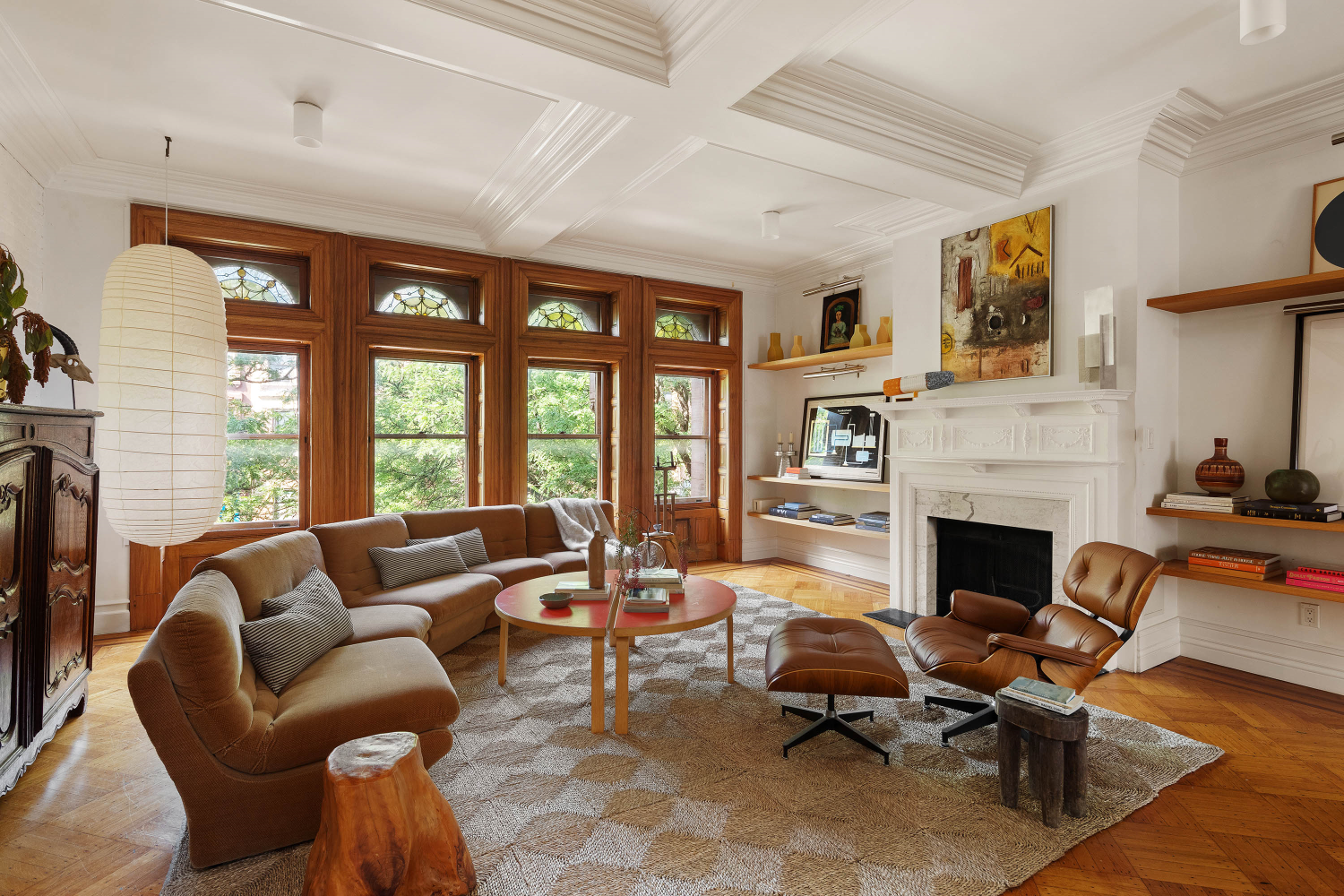 a living room with furniture fireplace and large windows