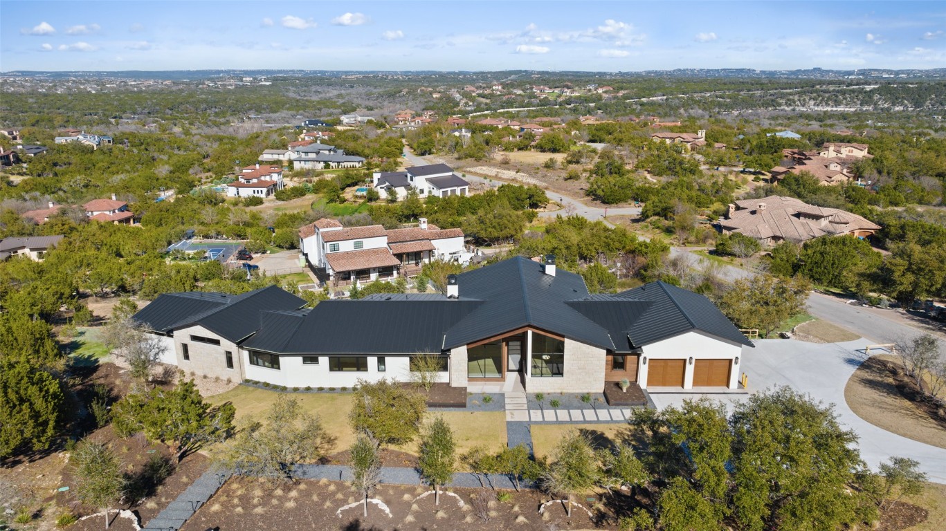 an aerial view of residential houses with outdoor space and trees