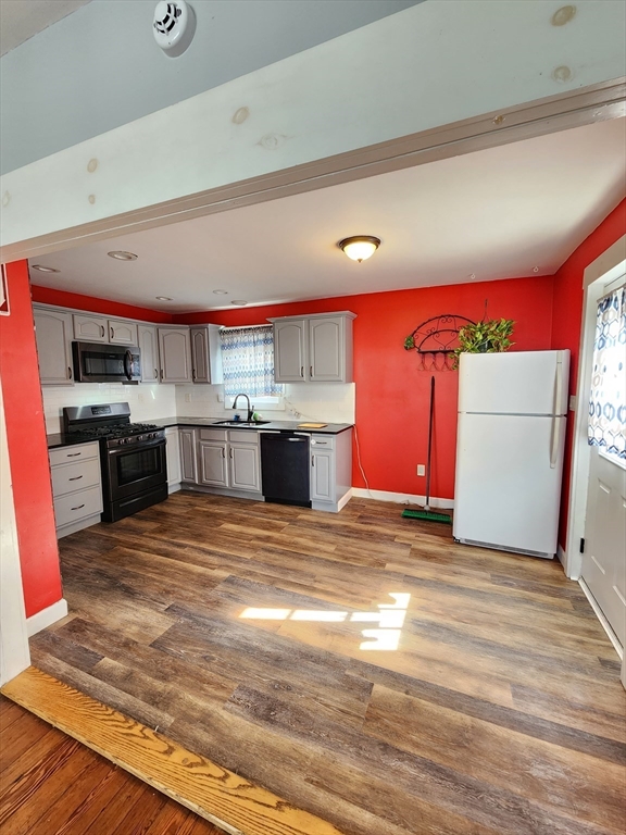 a view of kitchen with stainless steel appliances granite countertop a stove and a sink