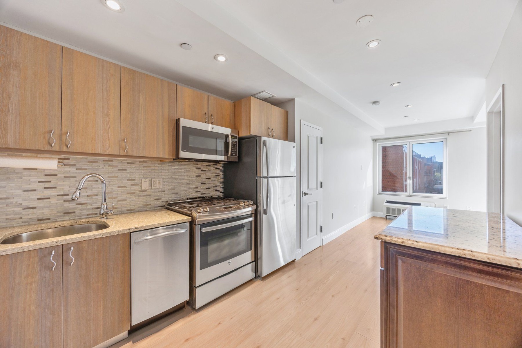 a kitchen with stainless steel appliances granite countertop a refrigerator sink and stove